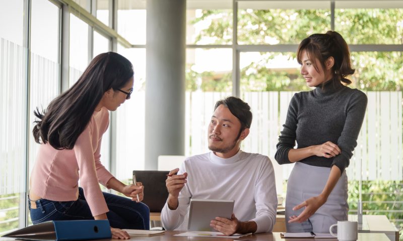 young asian businessman working with team in startup office 買収・譲渡が決まるまで伴走